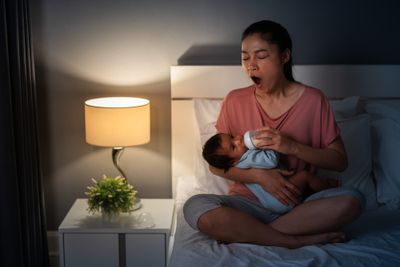 A mother feeding a formula to her baby.