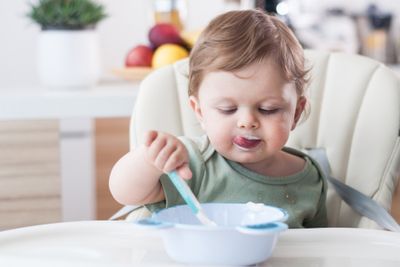 a young child eating cereal from a bowl