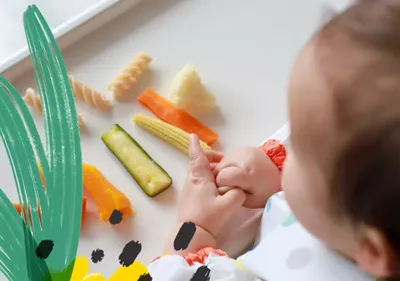 a baby playing with a variety of fruits and vegetables