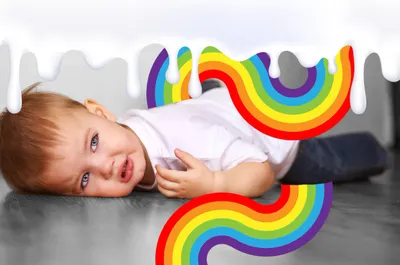 a baby laying on the floor with a rainbow design