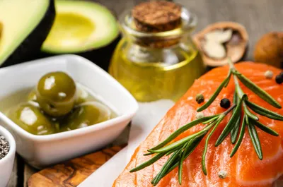 a close up of a plate of food with fish and olives