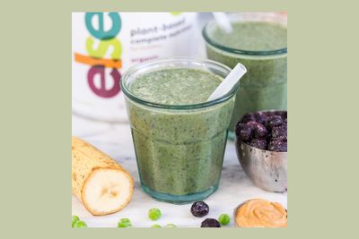 a green smoothie in a glass with a straw