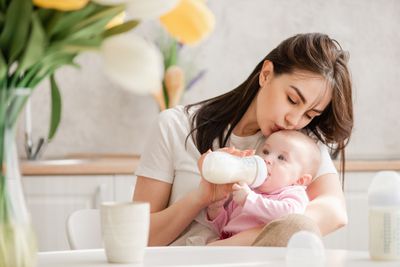 A woman feeding a baby with a bottle.