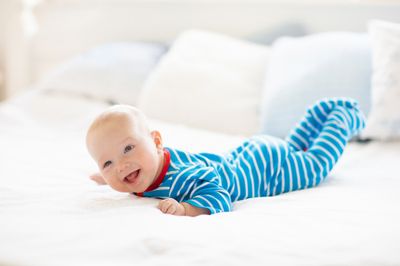 A baby laying on its tummy on a bed