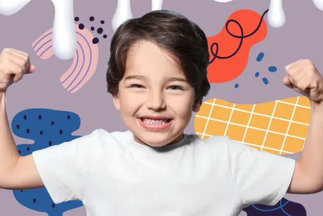 A young boy with his arms up in the air.