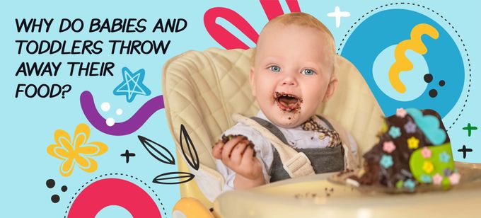 a baby in a high chair eating a piece of cake