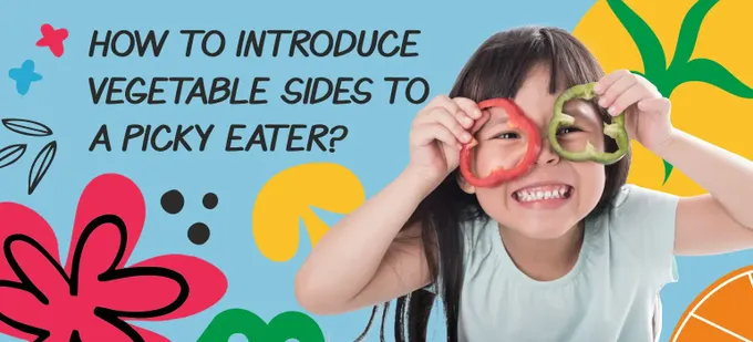 A young girl holding up 2 slices of capsicum to her eyes.