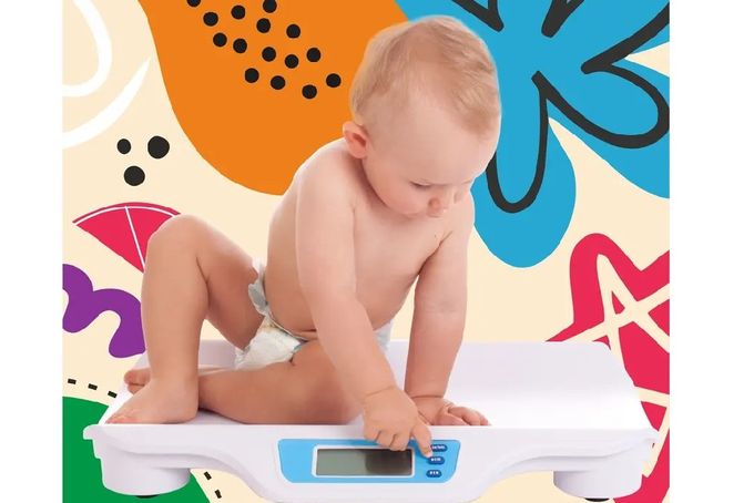 a baby is sitting on a scale and playing with it