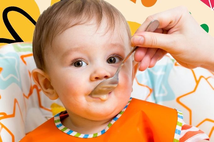a baby in an orange bib eating from a spoon