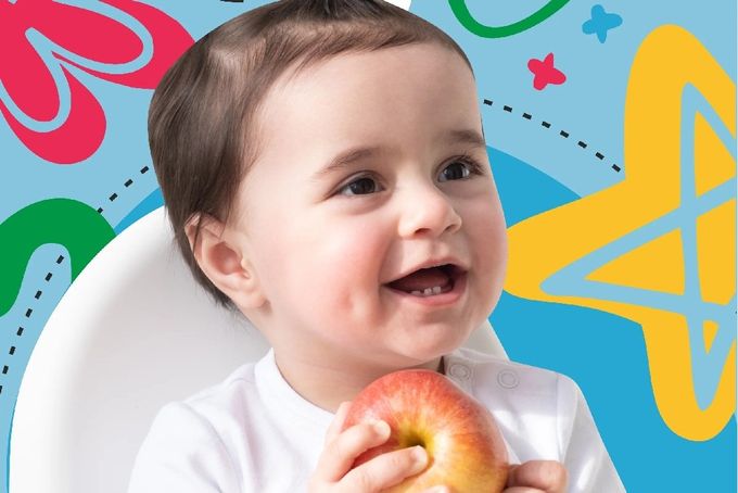 a baby in a high chair eating an apple