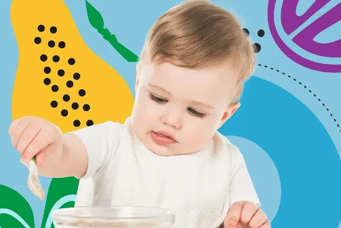 A baby is eating from a bowl with a spoon.
