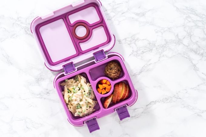 a purple lunch box with food inside of it