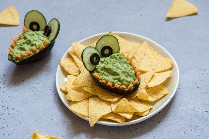 a plate of chips with a face made out of cucumbers