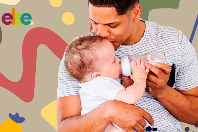 a man holding a baby and feeding it with a bottle