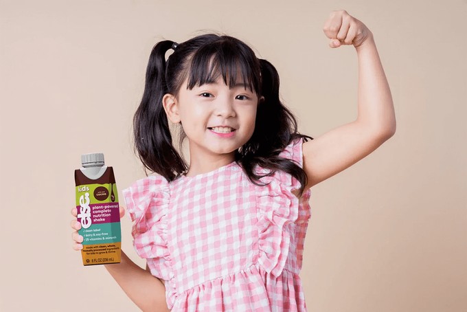 a little girl holding a bottle of sunscreen