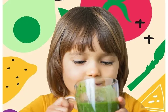 A little girl is drinking a green smoothie.