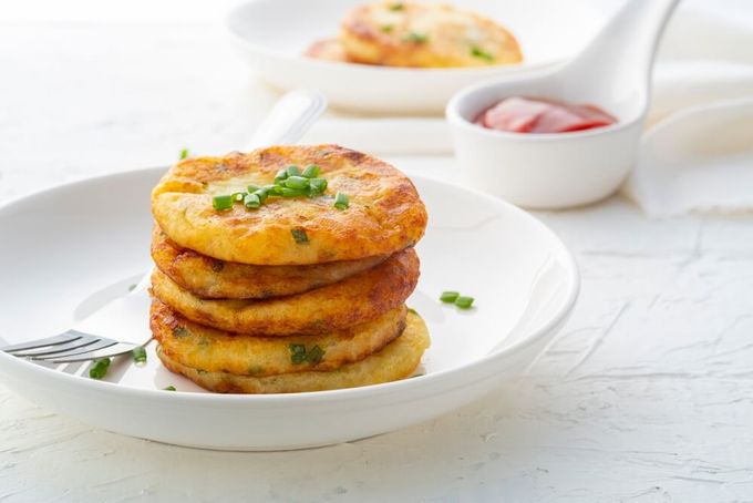 A stack of mashed potato cakes sitting on top of a white plate.