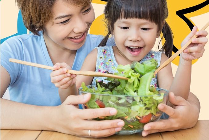 a woman and a little girl eating a salad