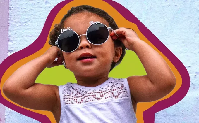 a little girl wearing sunglasses and a white shirt