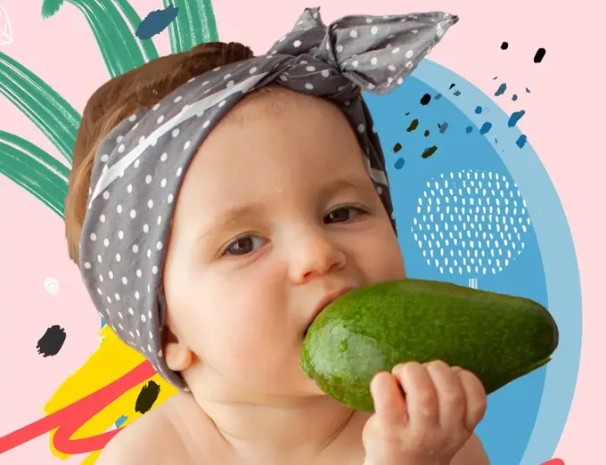 a baby wearing a bandana eating a cucumber