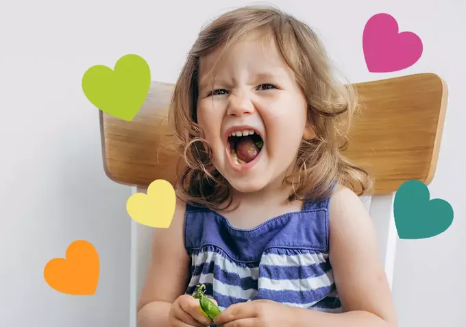 a little girl sitting in a chair with her mouth open