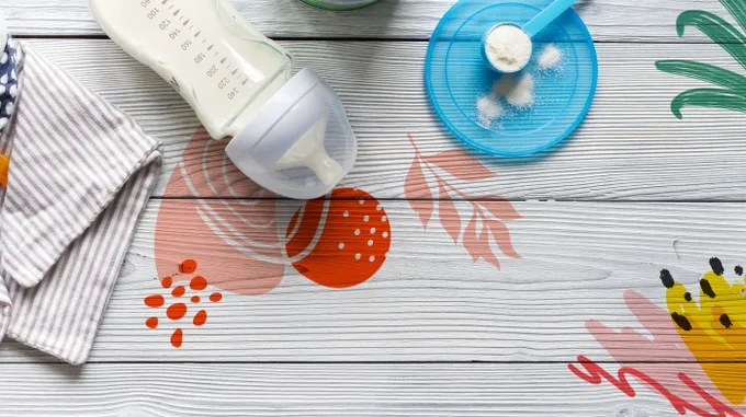 A bottle of formula and a cloth on a wooden table