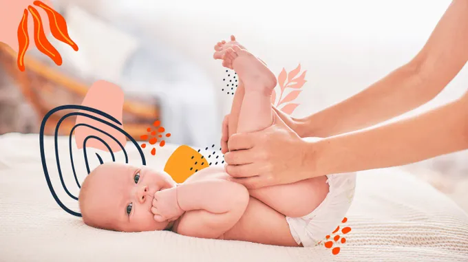 A woman is changing a baby on a bed.
