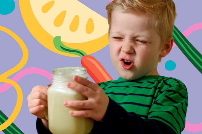 a young boy holding a jar of milk