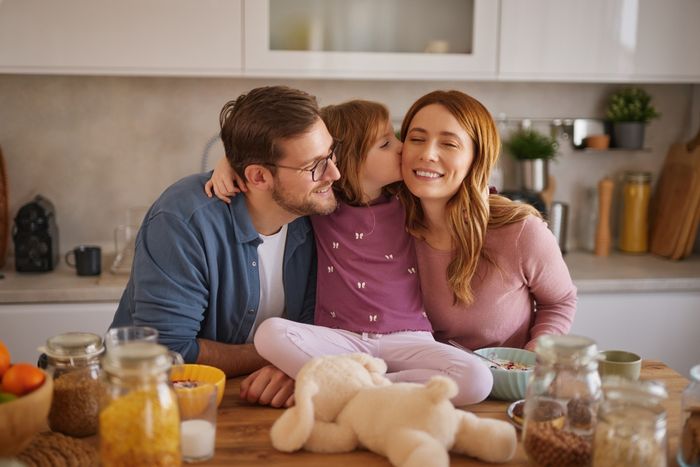 Happy family having breakfast at table in kitchen.