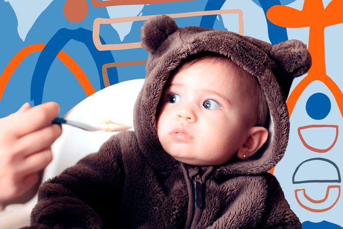 a baby in a bear costume eating cereal