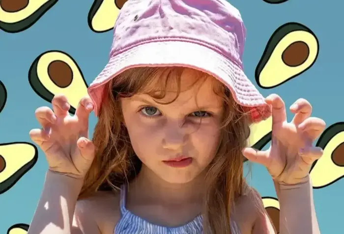 a little girl wearing a pink hat with her hands in the air