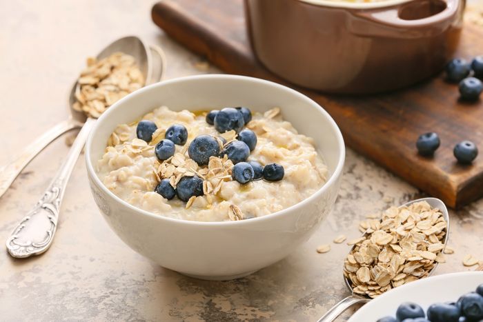 A bowl of oatmeal with blueberries and granola which is a food high in carbohydrates.