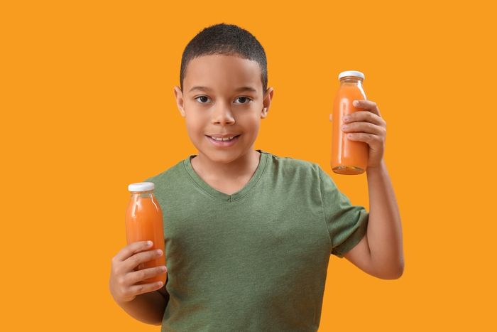 A boy holding a nutritional drink.