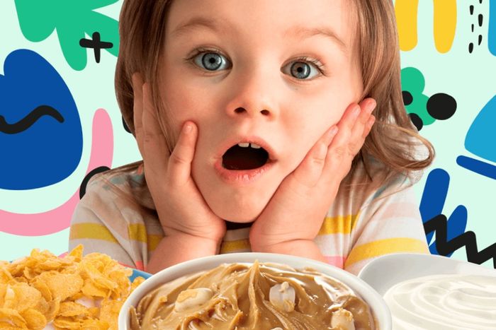 a little girl sitting in front of a bowl of cereal