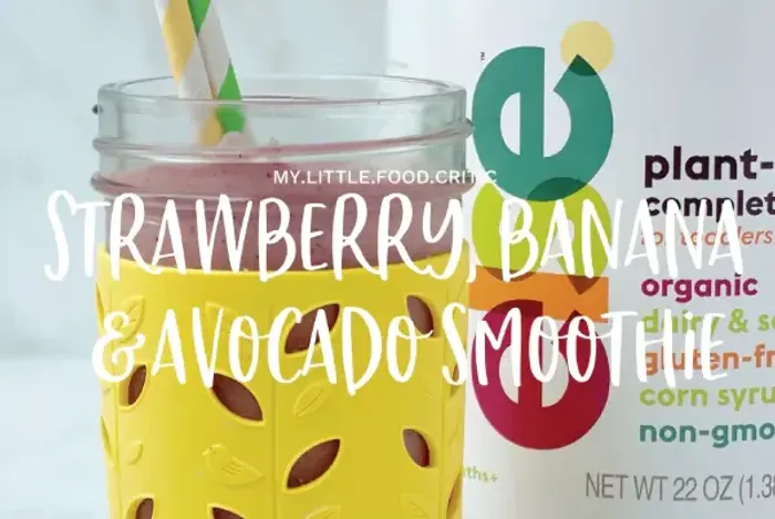 a glass with a straw in it next to a can of strawberry banana avoca
