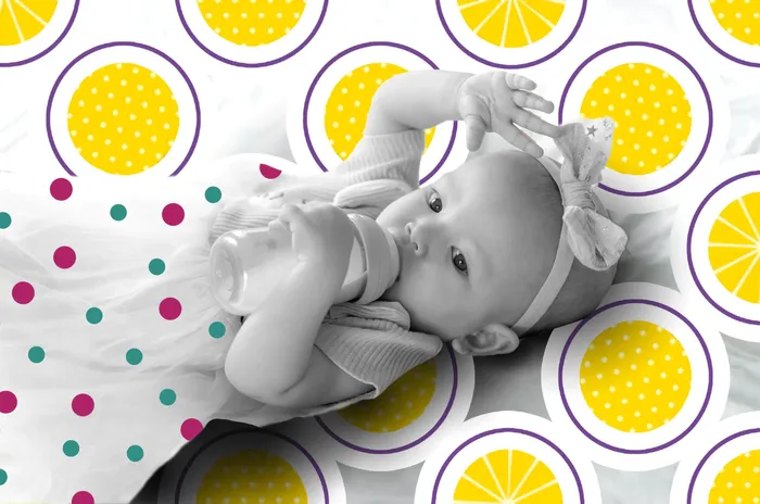 a baby laying on top of a bed next to a wall of circles
