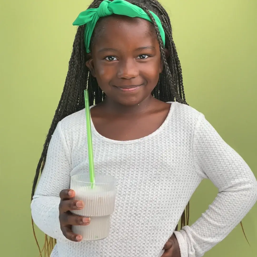 a young girl holding a drink in her hand