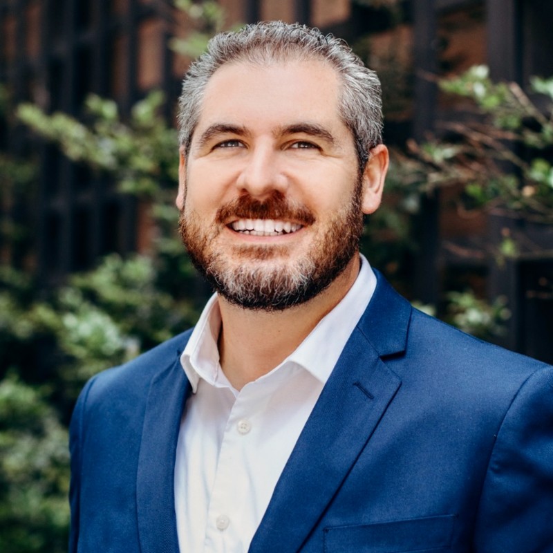 a man in a blue suit smiling for the camera