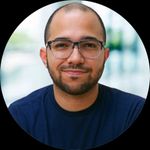 a man with glasses is smiling for a picture