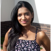 a woman standing in front of a brick wall