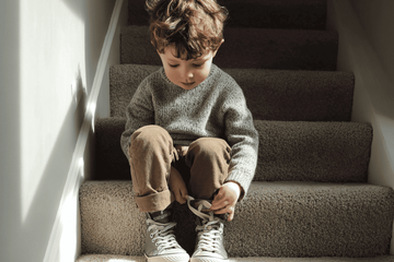 A young boy trying on shoes that will help him move better.