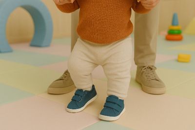 A kid walking while wearing first walker shoes.