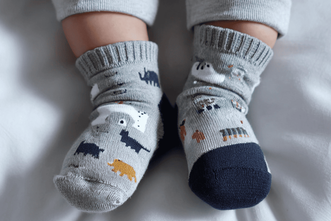A baby wearing socks so their feet are all covered up.