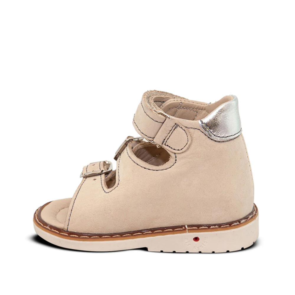 a little girl's white shoe with a metallic toe