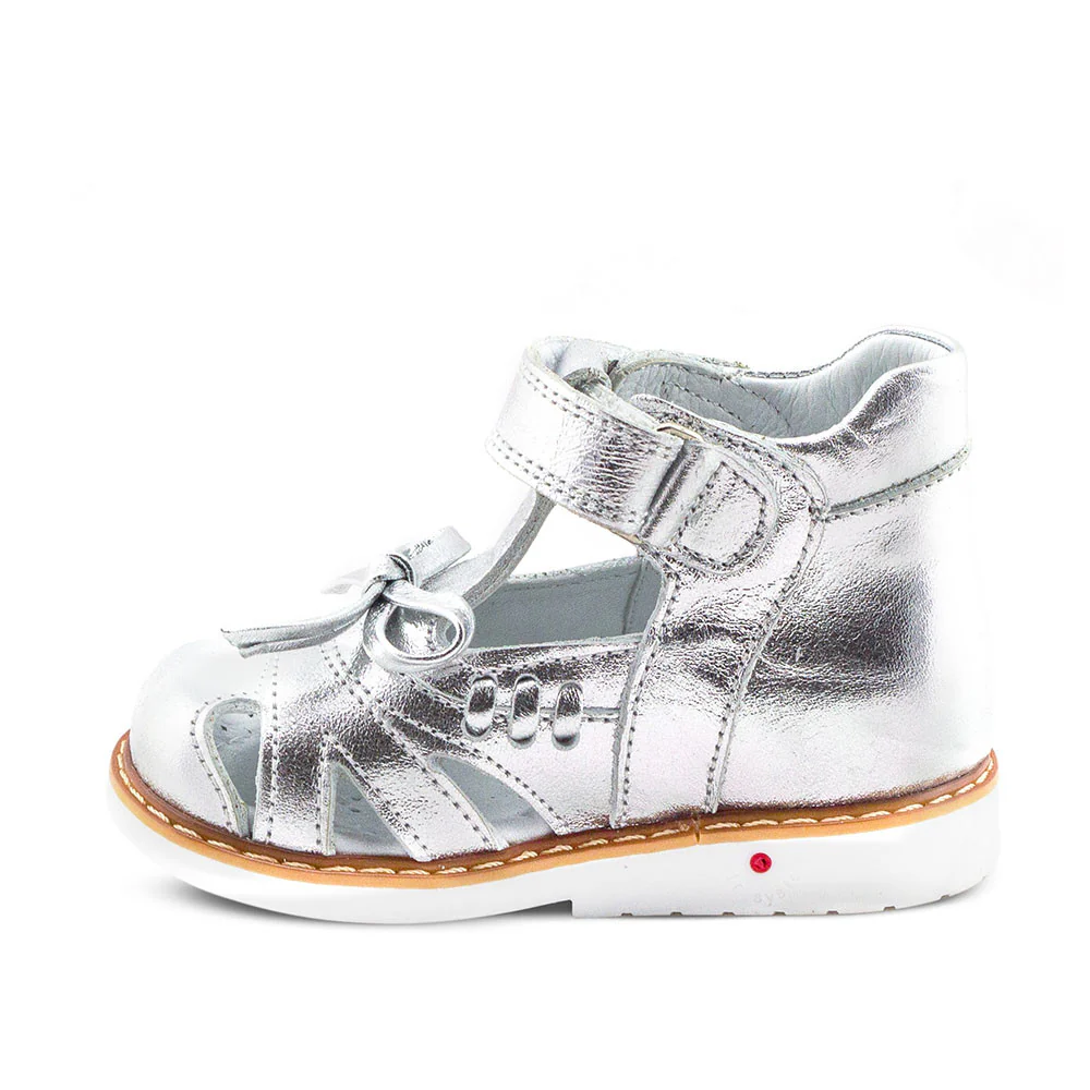 a child's silver shoe with a white sole