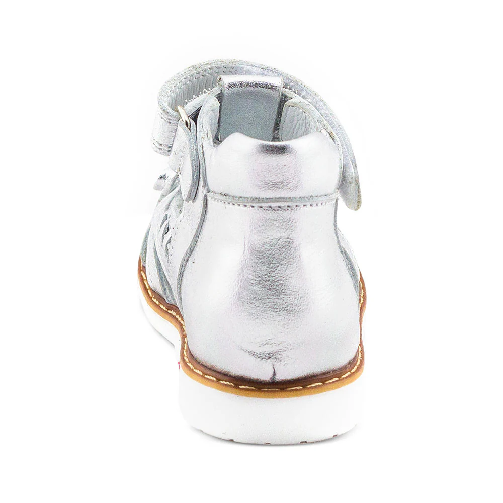 a child's silver shoe on a white background