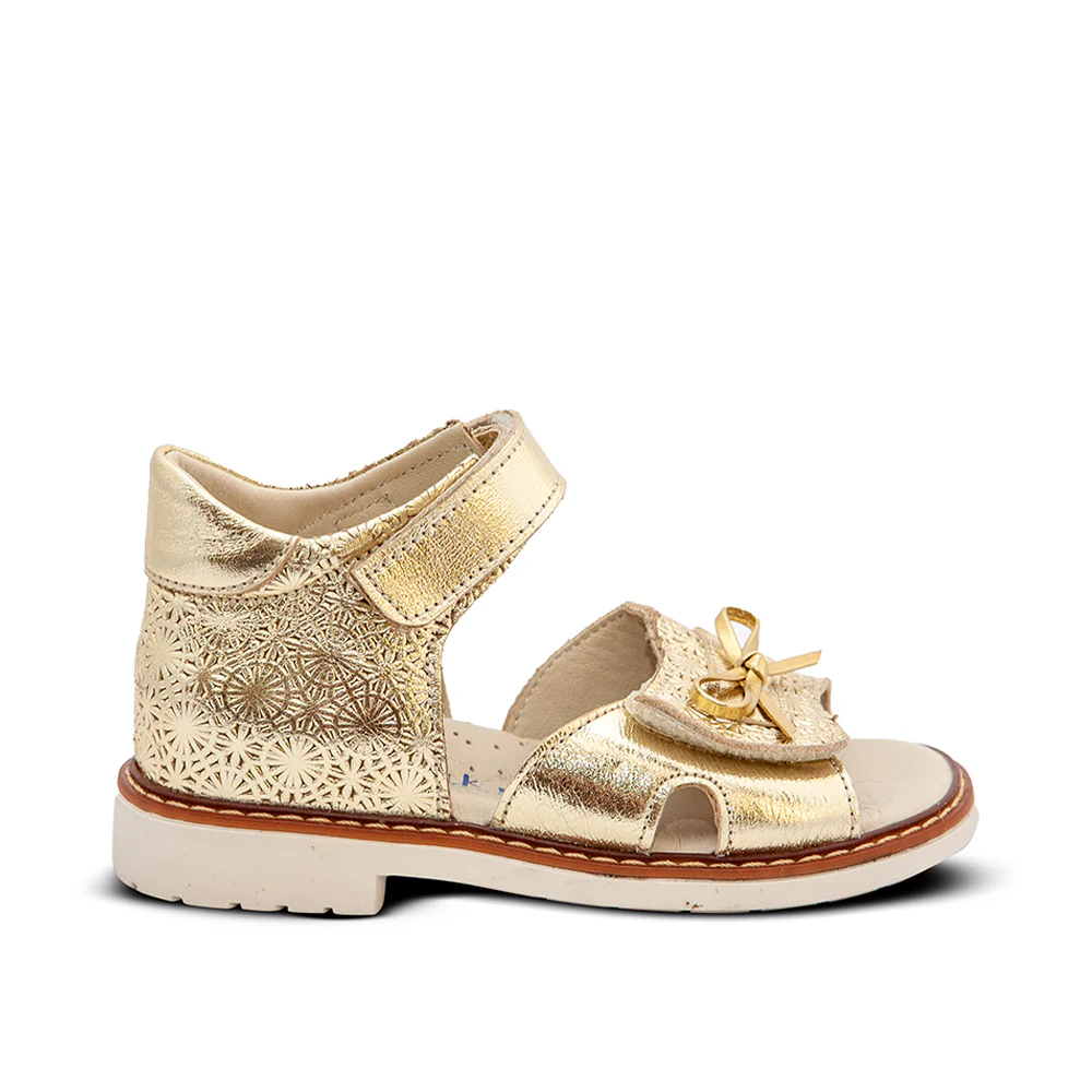 a little girl's gold sandals with a flower design