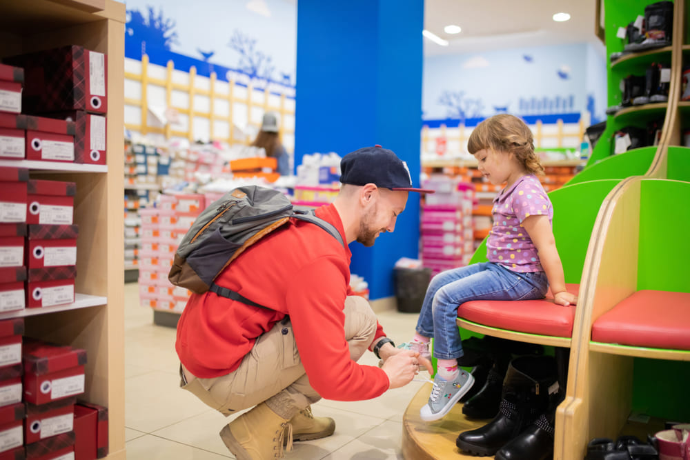 A dad choosing the best shoes for his little girl's growing feet.