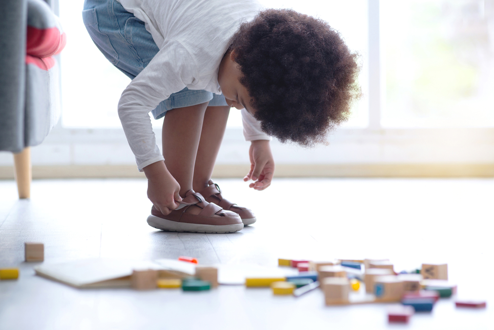 A kid putting on shoes.