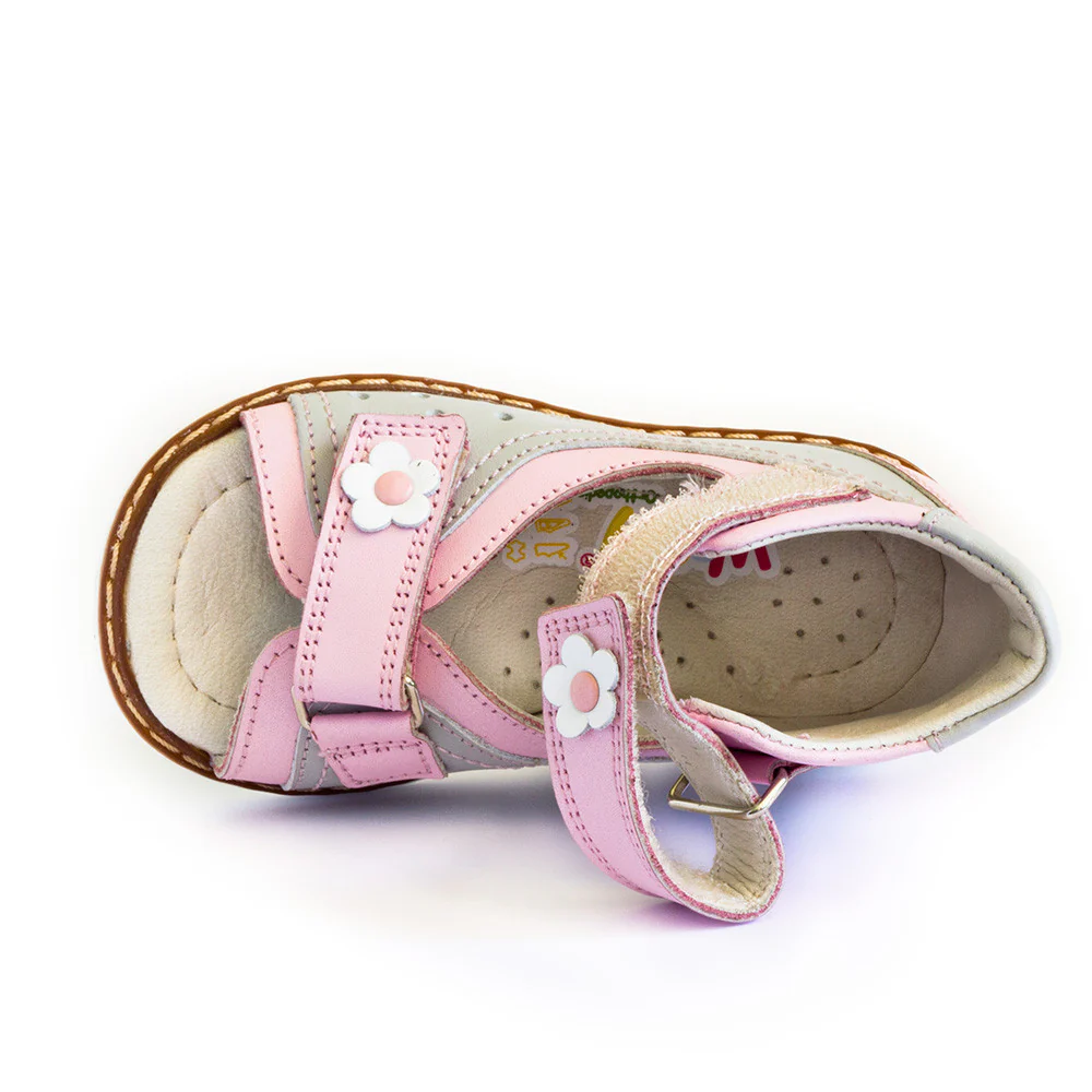 a little girl's pink and white shoes